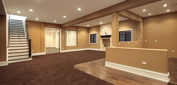 Tan finished basement with stairs, fireplace, recessed lights, carpet, and wood flooring