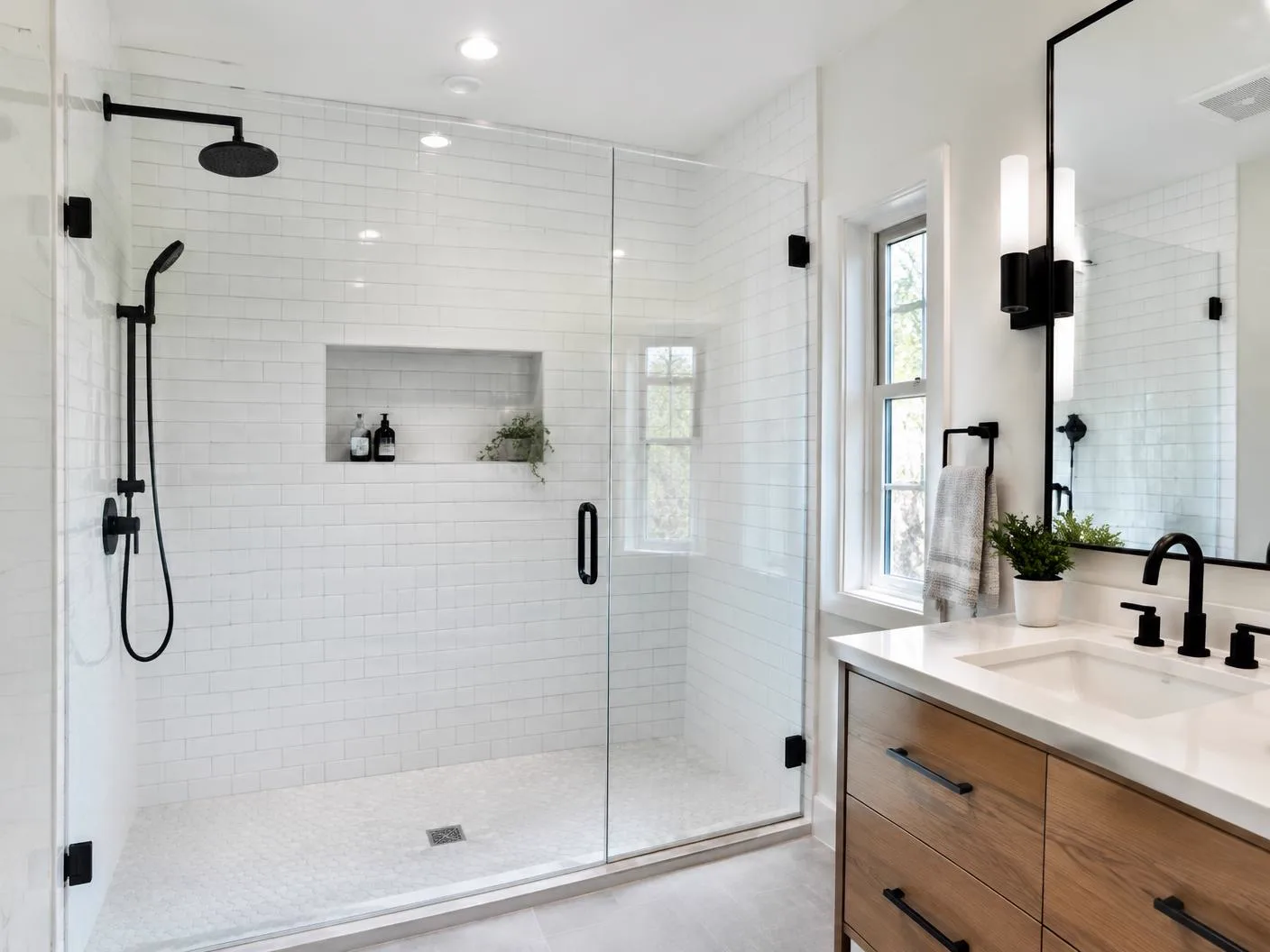 Walk-in glass shower with white subway tile and black fixtures