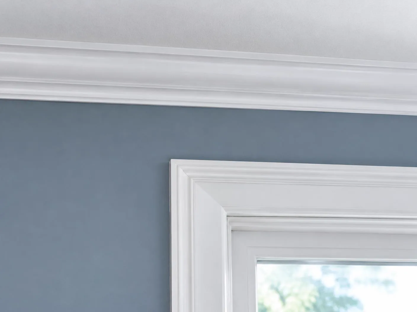 Crisp painted wall meeting white crown molding and window trim